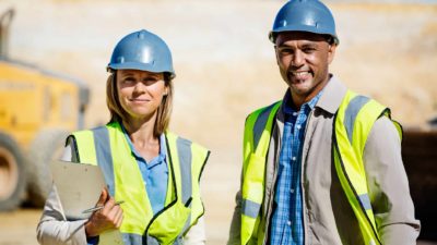 Two miners standing together with a smile on their faces.