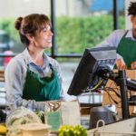 A customer and shopper at the checkout of a supermarket.
