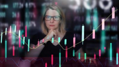 A woman looks quizzical as she looks at a graph of the share market.