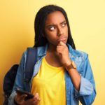 a woman puts her hand to her chin and looks to the side deep in thought as though pondering something significant.