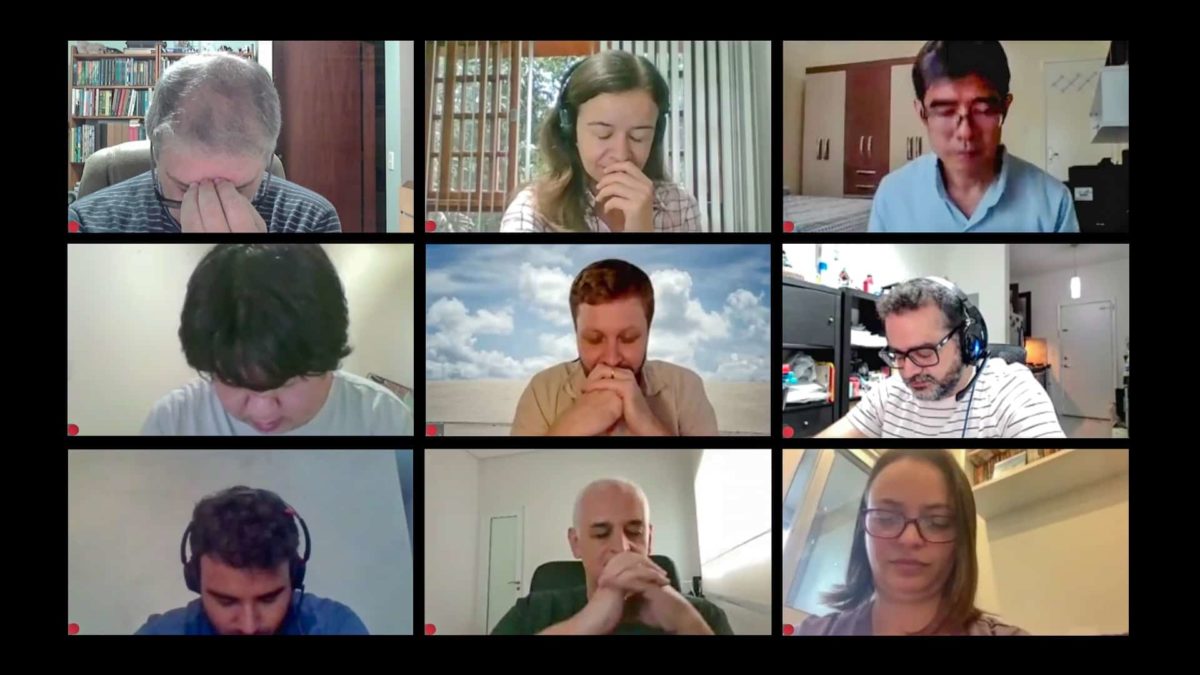 a group of nine people occupy nine windows on a zoom call wth a view of the computer screen. All nine of them are looking down or are making serious faces as though they are discussing bad news.