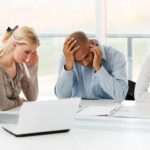 Group of stressful businesspeople having problems. sittong around a desk.