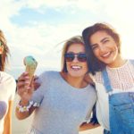 Three women cruise along enjoying ice-creams in the sunshine.