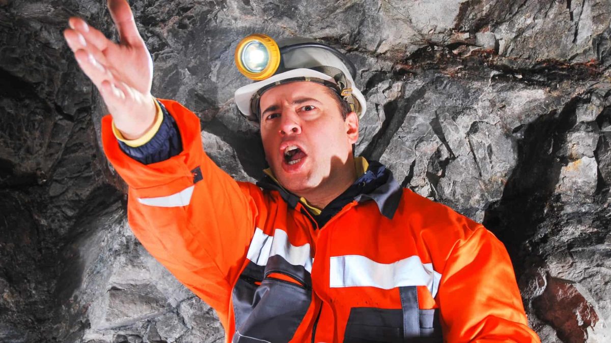 Miner gestures angrily in a mine.