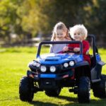 2 kids riding a mini toy vehicle
