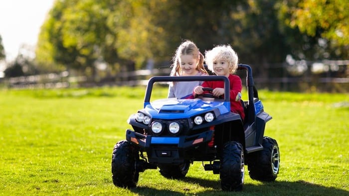 2 kids riding a mini toy vehicle