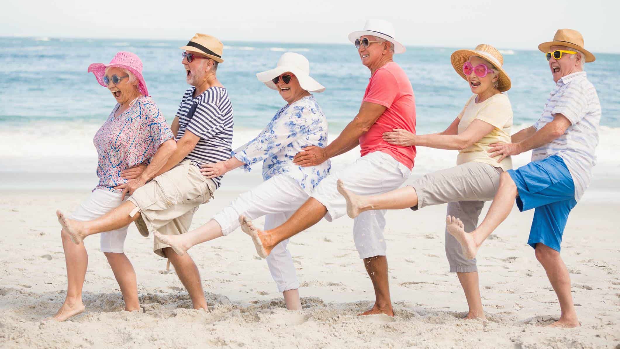Five retirees do a conga line dance on the beach celebrating the special dividend announced by Grange Resources today