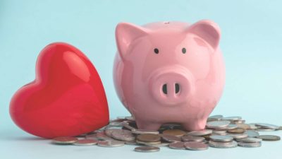 A heart next to a pink piggy bank and coins.