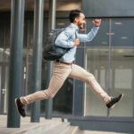 Man leaps as he runs along the street.