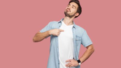 A smug young man points to his chest feeling proud that he invested in Polynovo shares which are rising today amid a market sell-off
