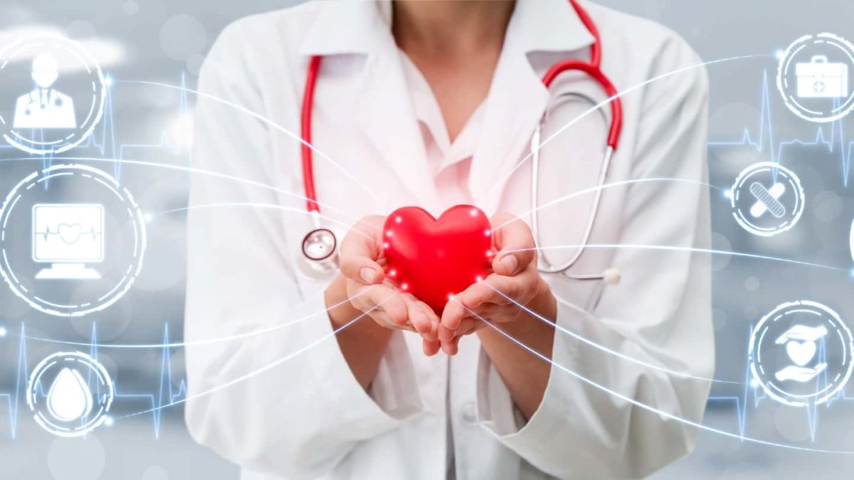 A medical specialist holds a red heart connected via technology and artificial intelligence (AI)