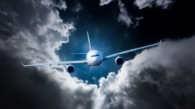 A plane flies into storm clouds, indicating the impact of climate change on businesses