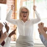 Team celebrating corporate success screaming with joy.