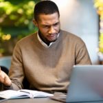 Man looks confused as he works at his laptop.
