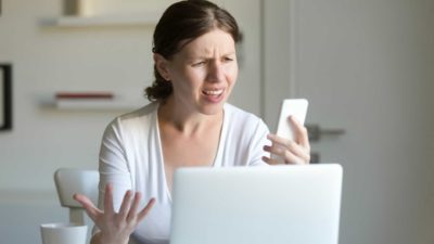 Woman has a confused expression as she looks at phone.