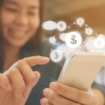A woman uses her mobile phone to make a purchase.