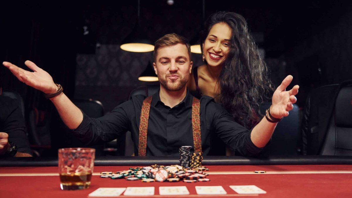 Man and woman sitting at casino table playing poker