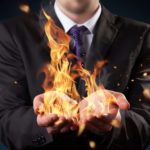 Concept image of man holding flames in both hands.