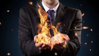 Concept image of man holding flames in both hands.