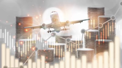 Concept image of a plane flying above a graph and stacks of coins.