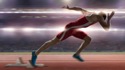 Runner jumps out of the starting blocks on a race track.