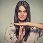an attractive woman gives a time out signal with her hands, holding them in a T shape, indicating a trading halt.