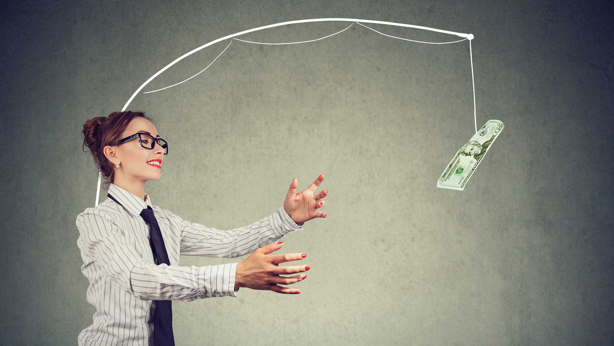 A woman reaches for money hanging from a fishing rod attached to her back, but she'll never chase it down.