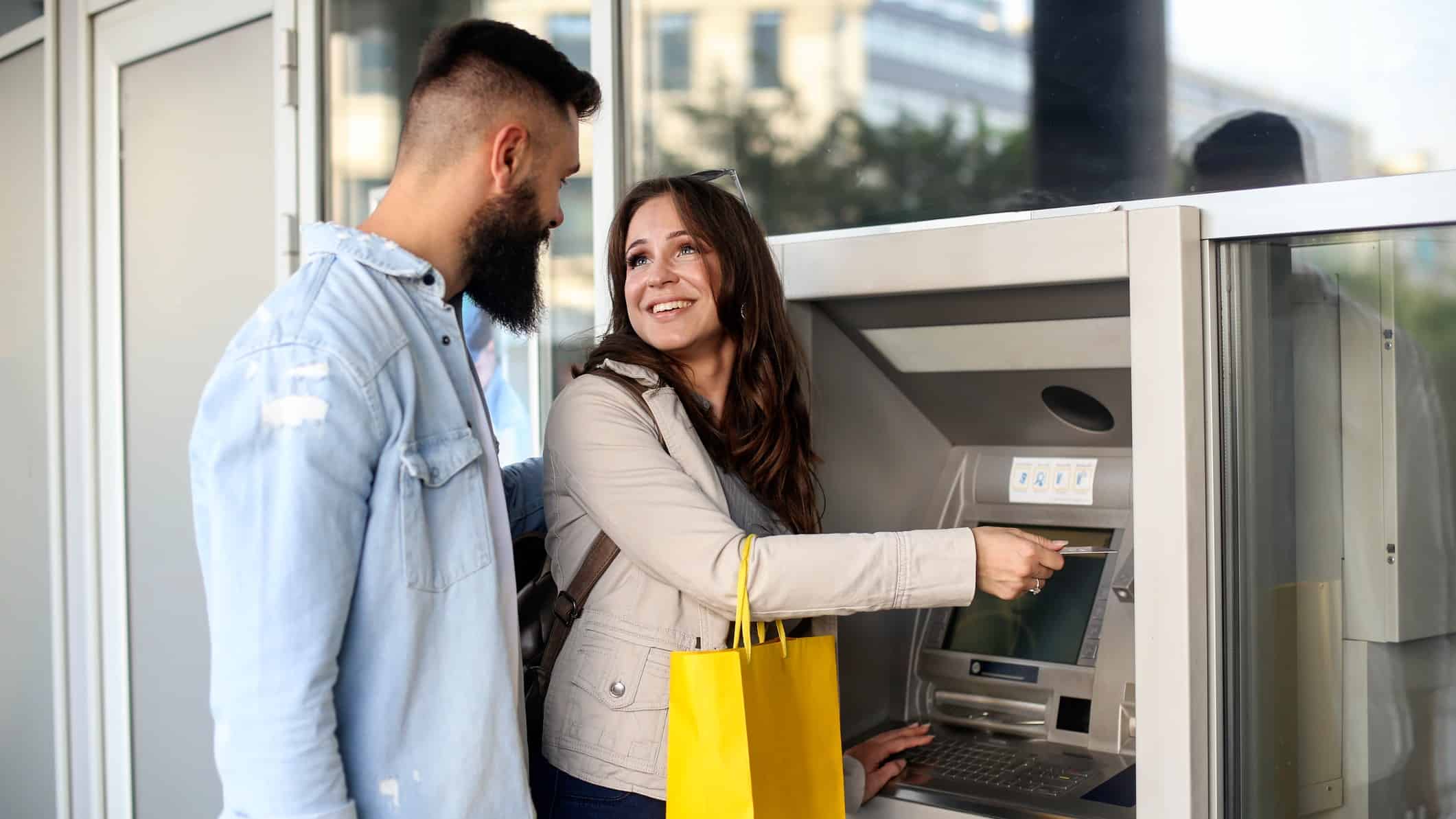 Happy couple at Bank of Queensland ATM machine.