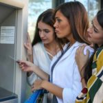 Friends at an ATM looking sad.
