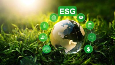 An image showing green grass and sunshine and the abbreviation ESG which means environmental social governance. A globe is also shown with environment-related symbols surrounding it in small green circles representing a Westpac report on ESG investing