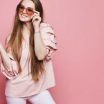 Happy woman holding high heels.