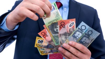 Man holding different Australian dollar notes.