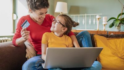 Mother and child happy whilst paying on their laptop.