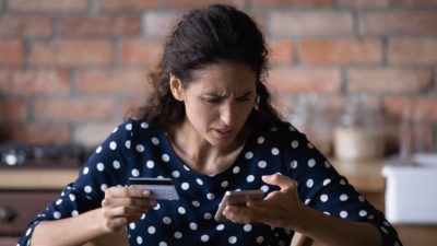 Woman looking sad while paying.