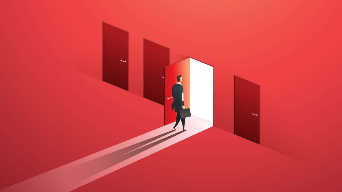 Concept of a businessman walking through one open door amid three other closed doors.