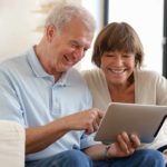 A happy couple looking at an iPad.