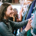 Happy girl shopping at clothes shop.