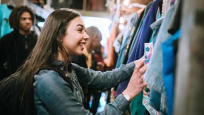 Happy girl shopping at clothes shop.