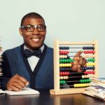 An accountant gleefully makes corrections and calculations on his abacus with a pile of papers next to him.