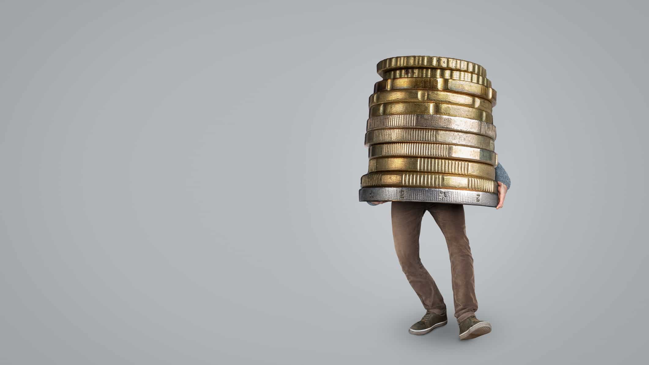 A person is weighed down by a huge stack of coins, they have received a big dividend payout.