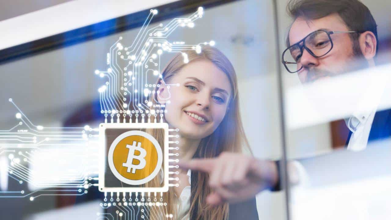 Two investors look at a graphic showing a bitcoin in the centre