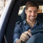 Smiling man at the wheel of a car.