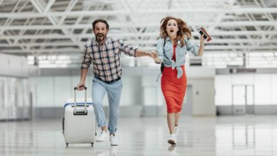 A couple are running late for their flight as they rush to the gate.