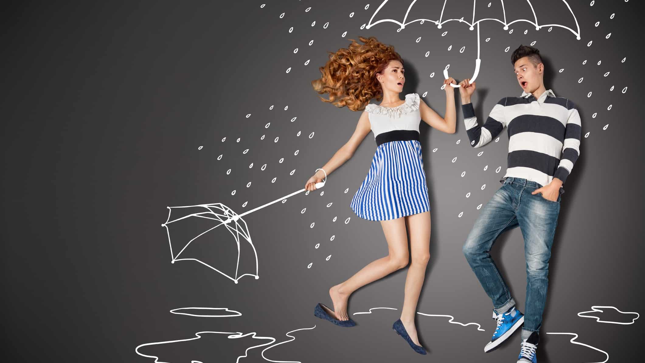 A woman steps into a friend's umbrella after hers blows away.