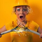 A woman wearing a hard hat holds two sparking wires together as energy surges between them. representing the rising Li-S Energy share price today