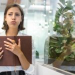 A businesswoman exhales a deep sigh after receiving bad news, and gets on with it.