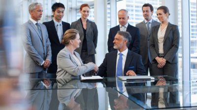 Two CEOs shaking hands on a deal.