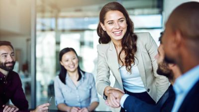 Woman shaking the hand of a man on a deal.