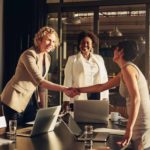 Two women shaking hands on a deal.