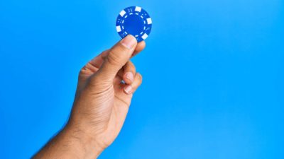 Person holding a blue chip.